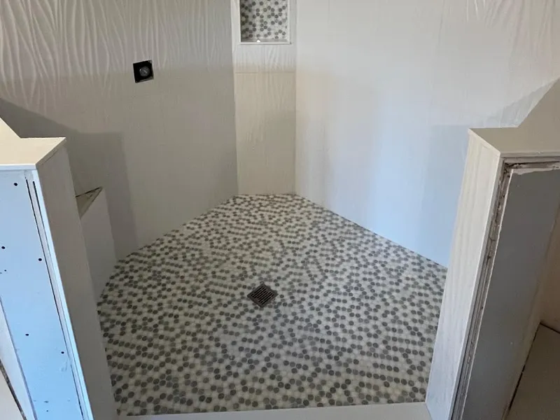 Walk-in shower with pebble mosaic floor