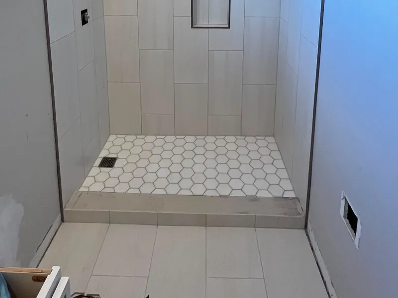 Tiled shower with niche and white hex floor