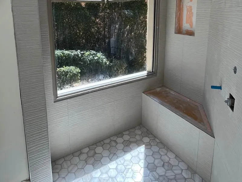 Shower with window, built-in bench, and hex tile floor