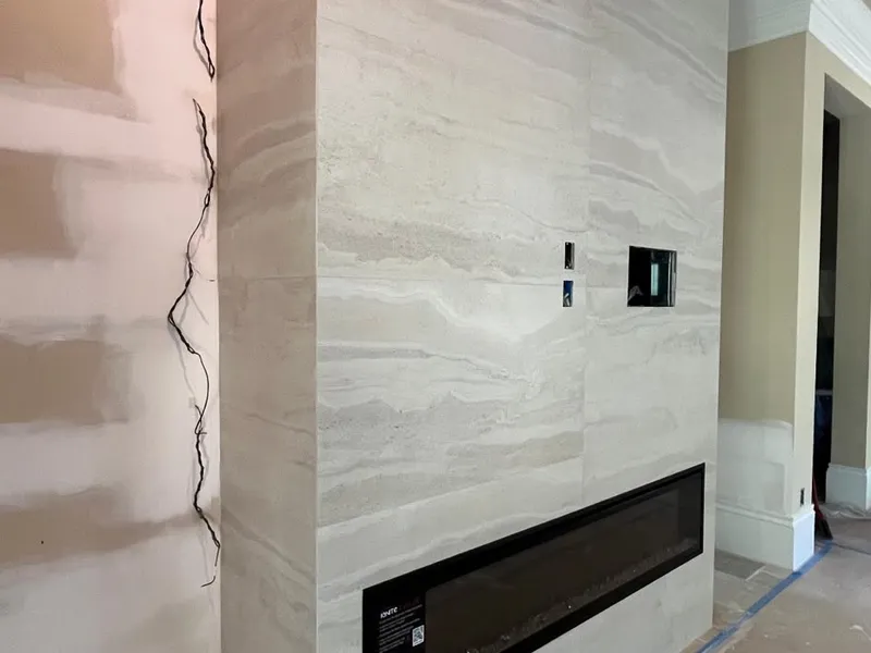 Floor-to-ceiling tile fireplace wall with linear fireplace