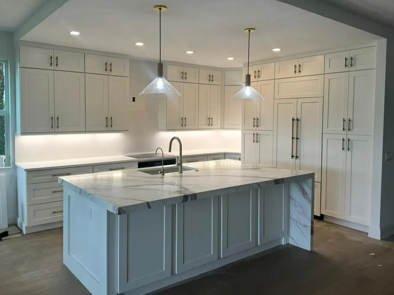 Same kitchen from the side, floor-to-ceiling white cabinets