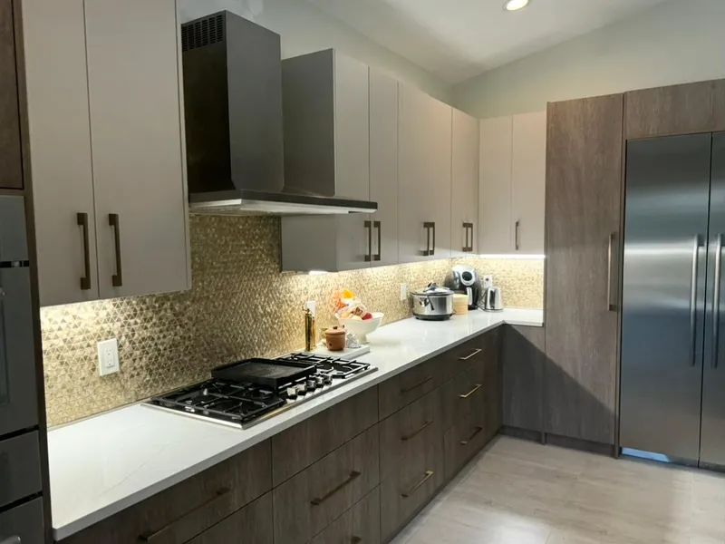 Two-tone kitchen with wood cabinets, mosaic backsplash, and gas cooktop