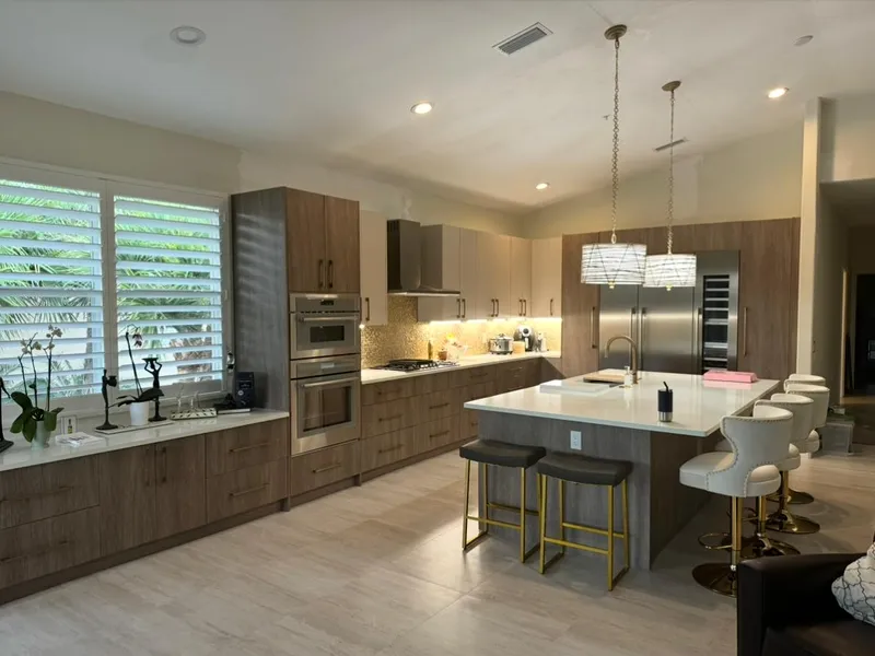Open kitchen with wood cabinets, quartz island, and bar seating