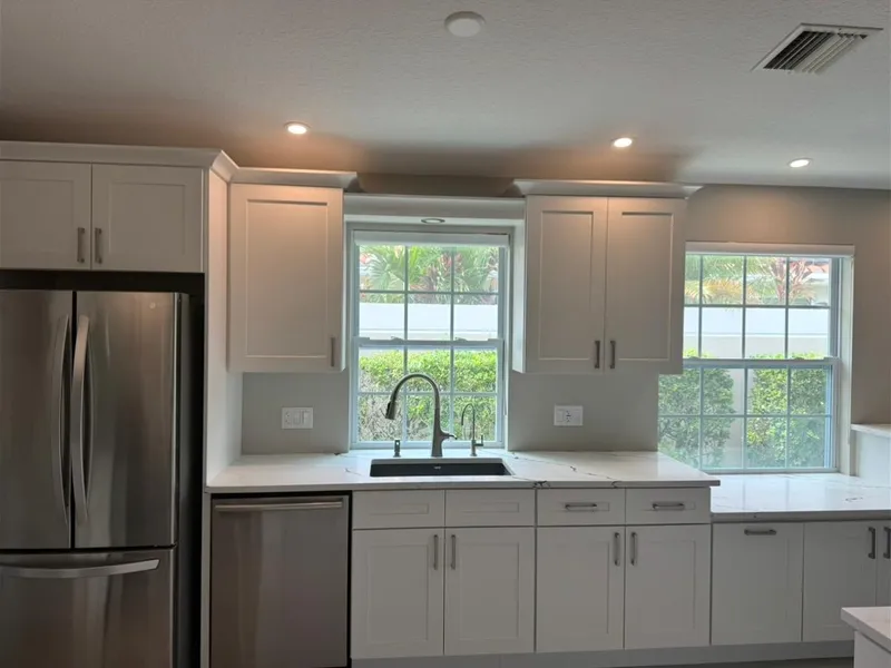 White shaker kitchen with sink under twin windows